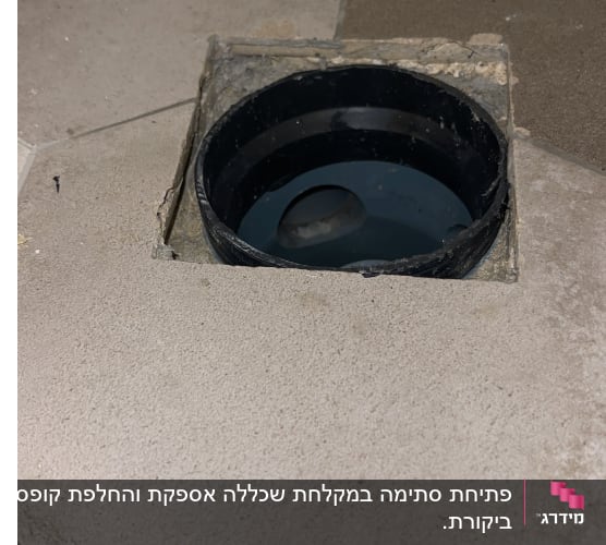 פתח ניקוז עגול ברצפה עם מים בתוכו